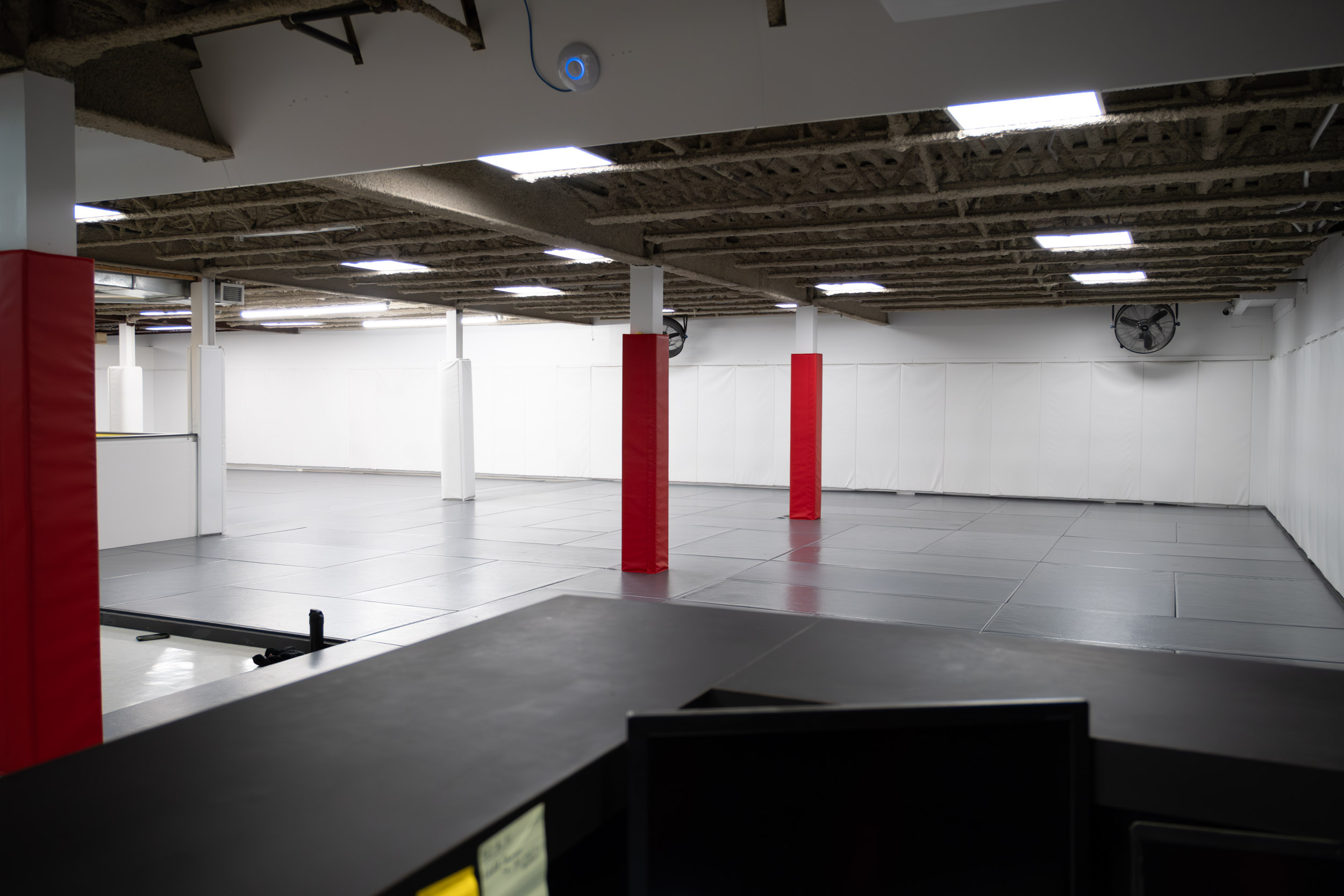 Salle de jiu-jitsu avec tatamis gris